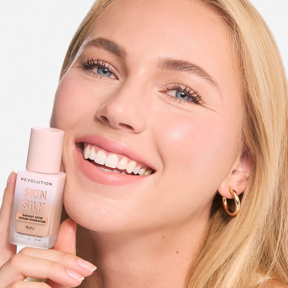 Model wearing and holding the Revolution Skin Silk Serum foundation